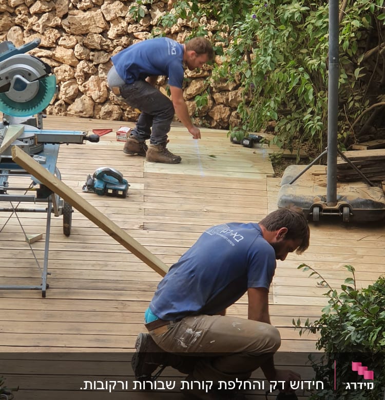 שני אנשים עובדים על דק עץ עם כלים חשמליים